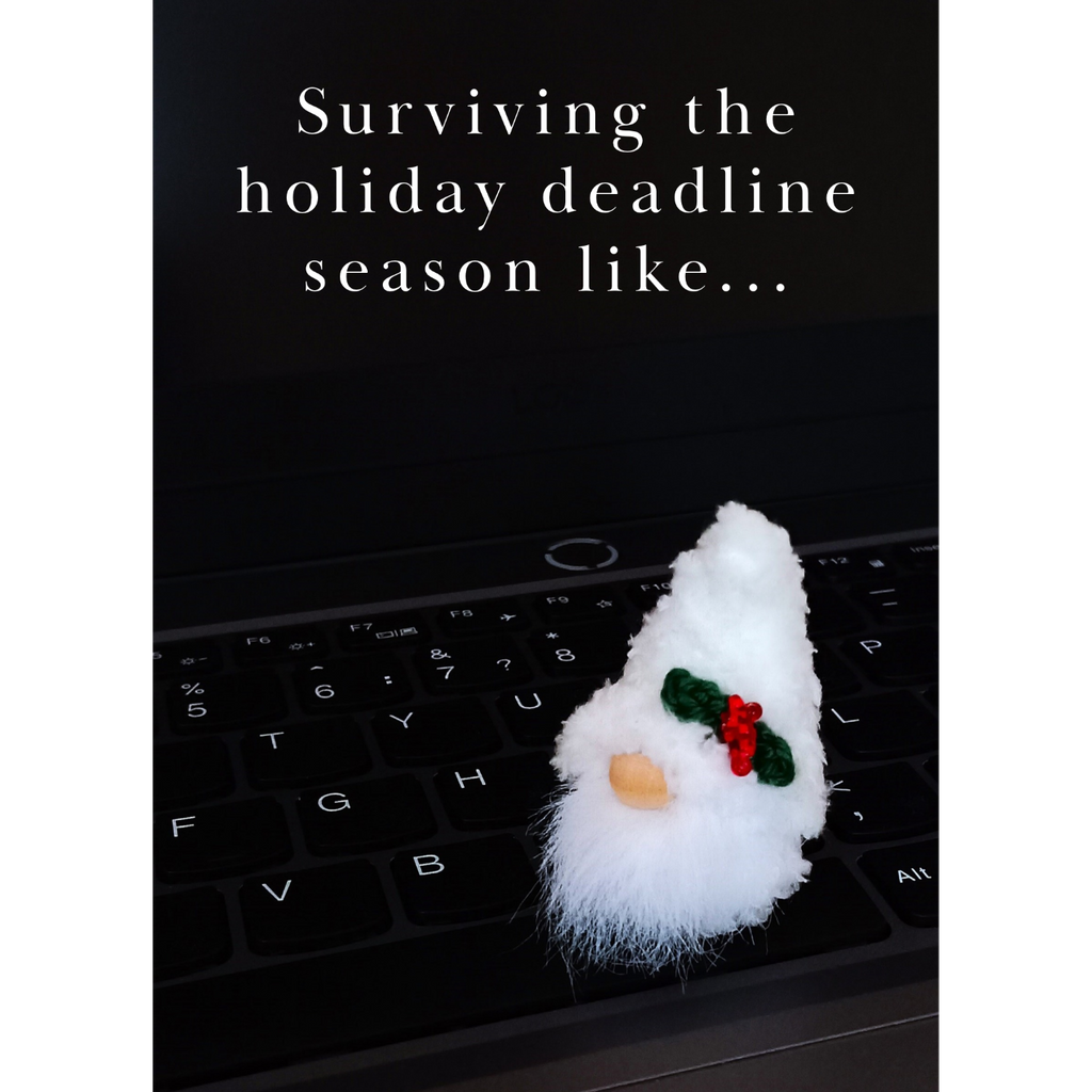 A printable corporate holiday card with a white fluffy handmade desk pet plush gnome on a dark modern laptop keyboard. Styled typographic white text over the dark screen background reads: 'Surviving the holiday deadline season like...'.