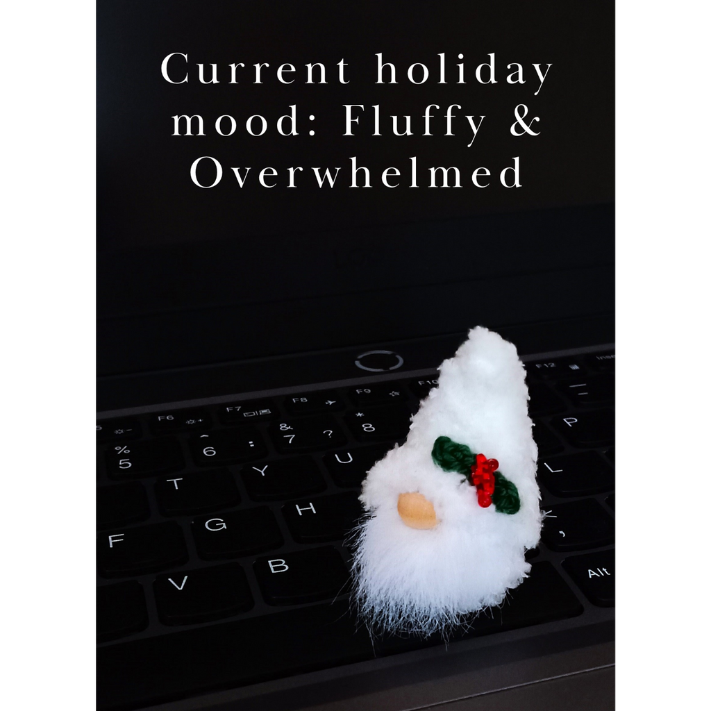 • A funny workplace digital download postcard. A cute fluffy white miniature Christmas gnome plush companion is placed on a sleek black laptop. The elegant centered typography reads: 'Current holiday mood: Fluffy & Overwhelmed'.
