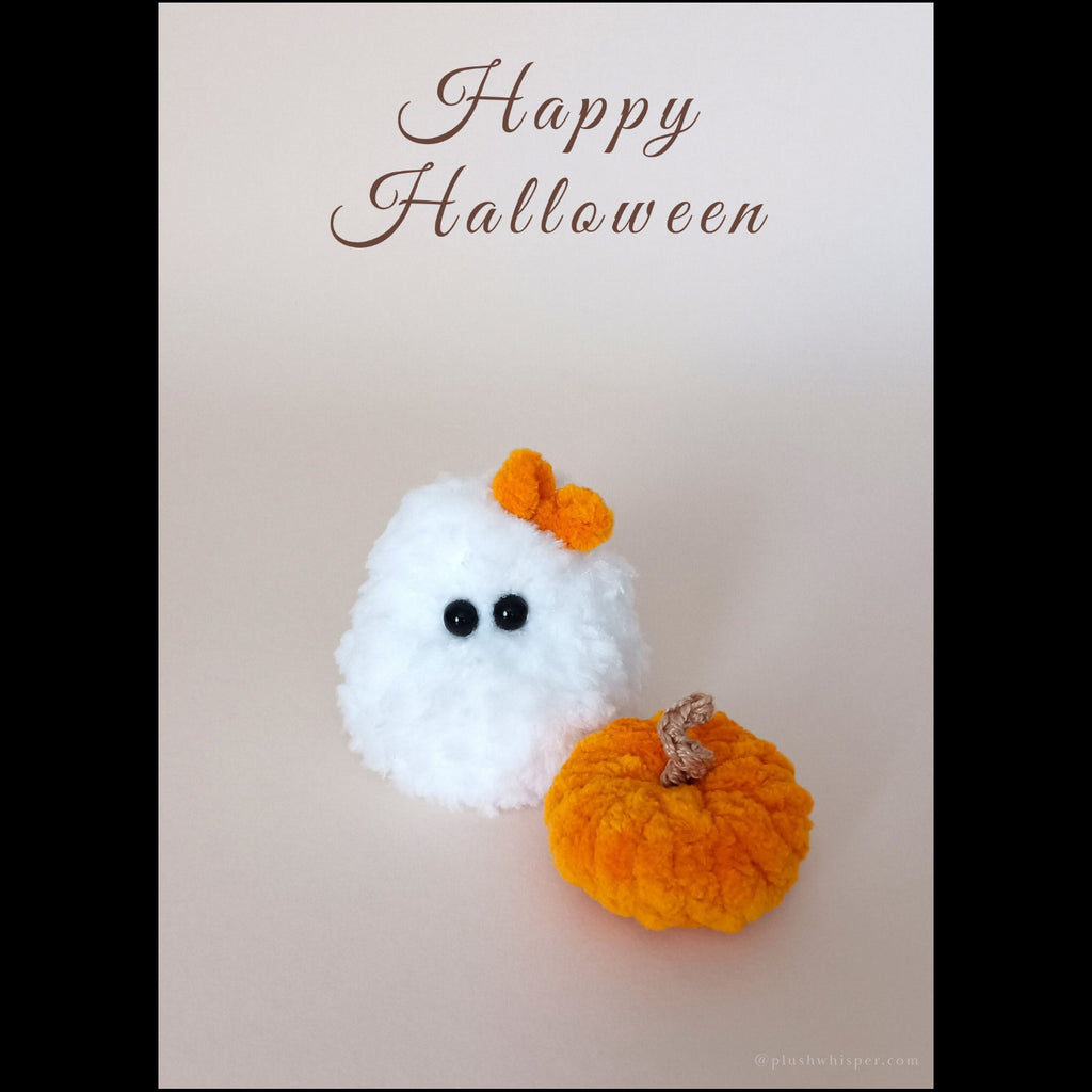A printable high-resolution flat lay of an interior desk card with a tiny white ghost crafted from premium fluffy crochet yarn and an orange textile pumpkin on a neutral beige background. Fine chocolate brown typography across the top reads Happy Halloween. Designed as a unique handmade gift for coworkers, book lovers, and friends.