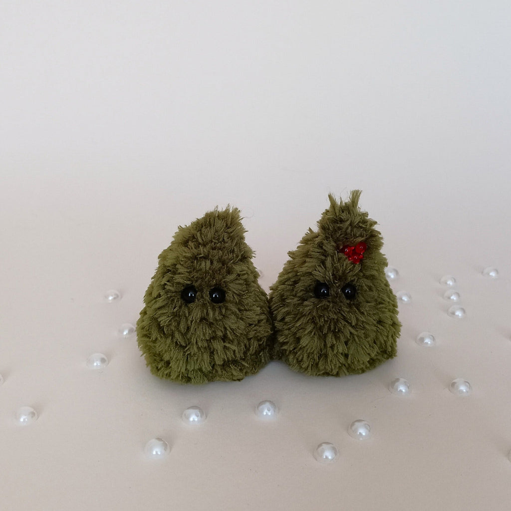Two tiny handmade green crochet Christmas trees, one with red berry decoration, fluffy holiday desk companions