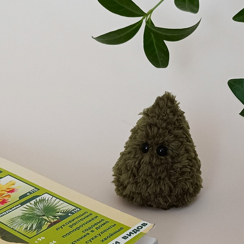 Tiny green crochet Christmas tree without decorations styled with green leaves, handmade fluffy miniature forest and holiday decor