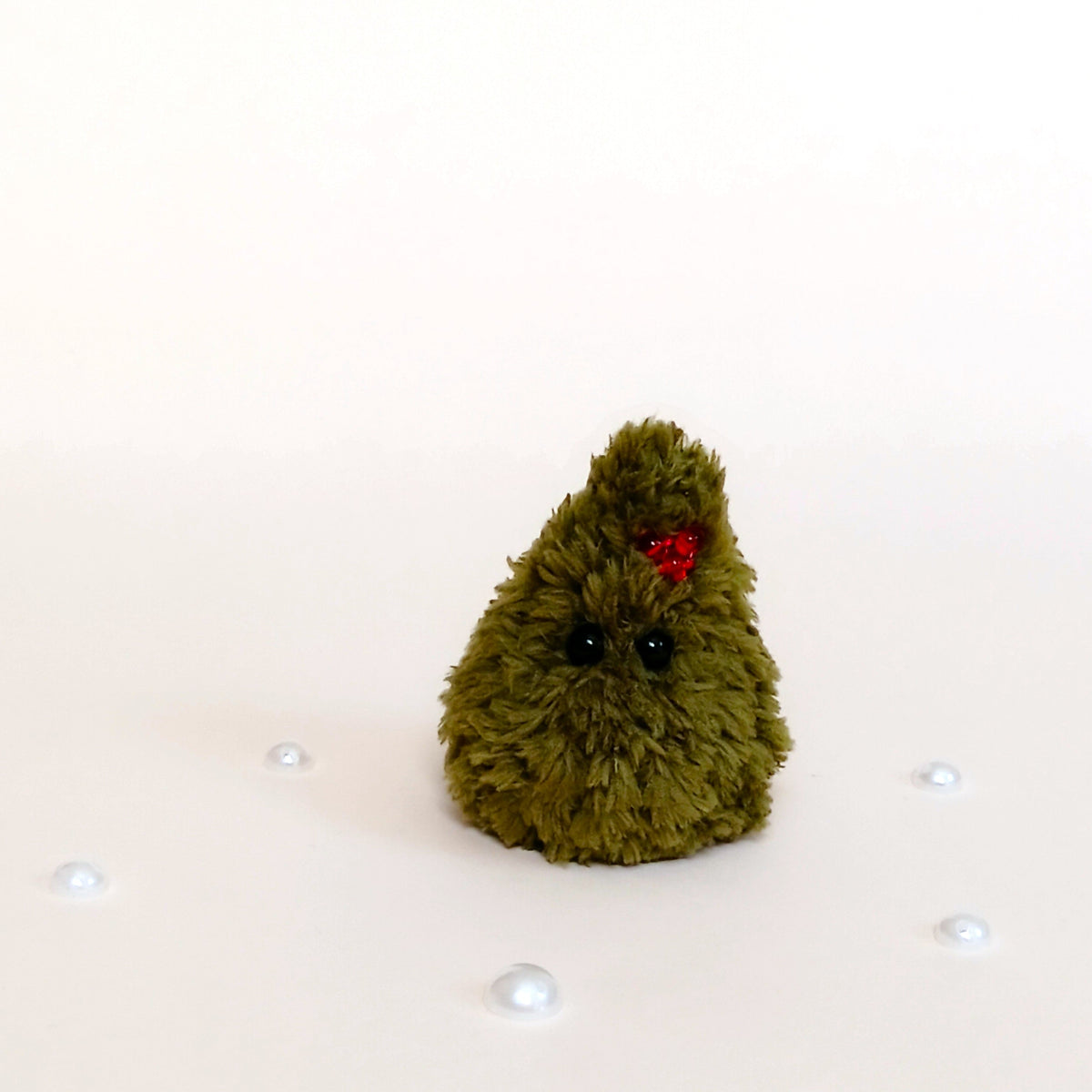 Tiny handmade green crochet Christmas tree with red berry decoration, fluffy holiday desk and shelf companion