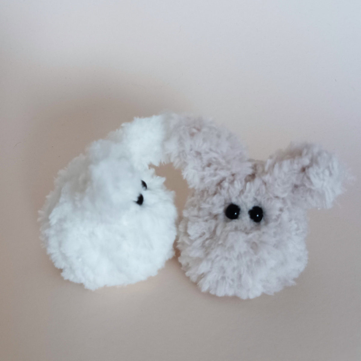 A pair of miniature handmade fuzzy bunny plush desk pets in solid white and heather grey colors standing together. Soft pocket sized pocket pets variation overview and cute aesthetic home office companion pack.