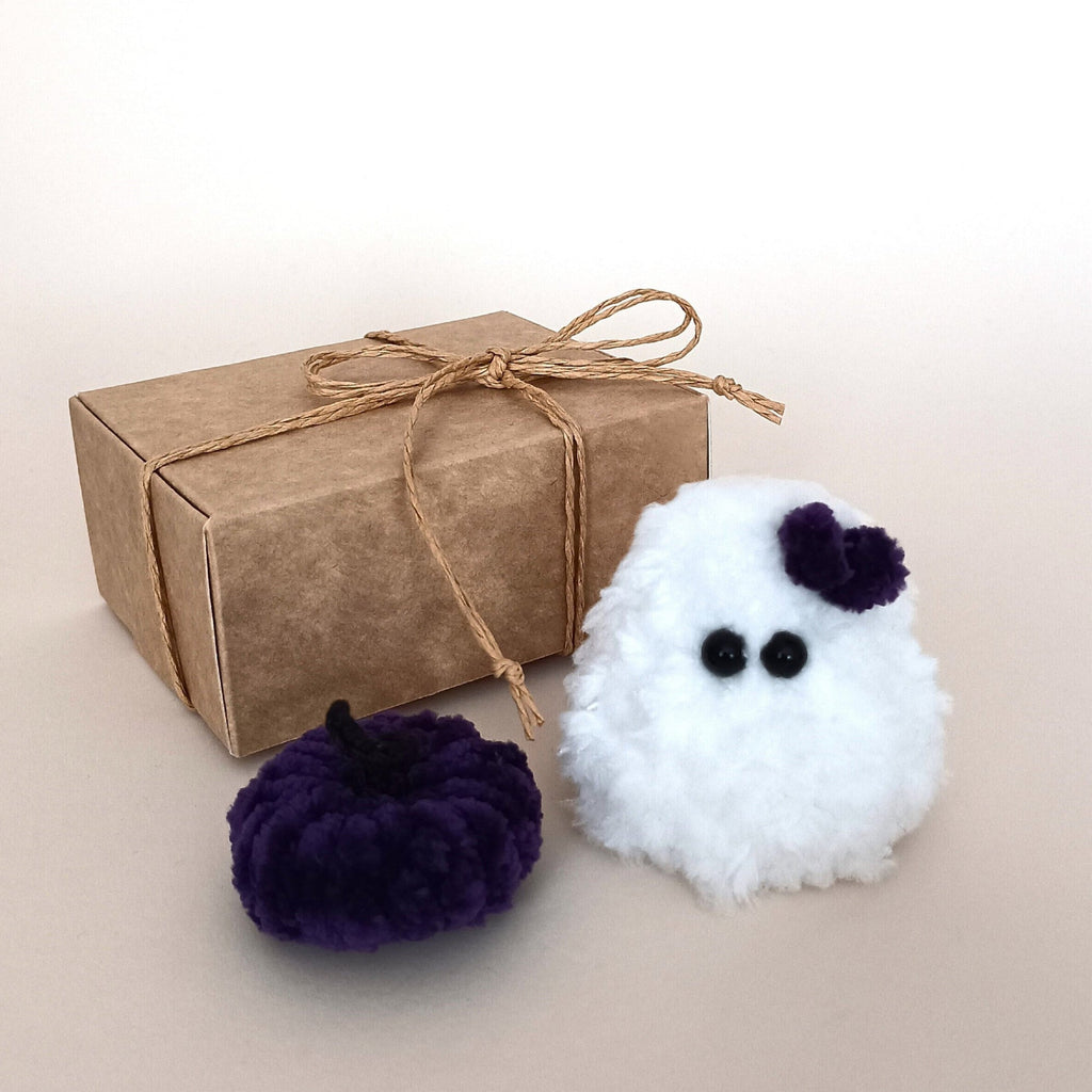 White handmade ghost with a purple bow and matching purple pumpkin beside a kraft gift box, a tiny Halloween decor gift set